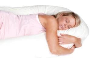 Woman using the CuddleUp Body Pillow available online and in-store at The Back and Neck Bed Shop