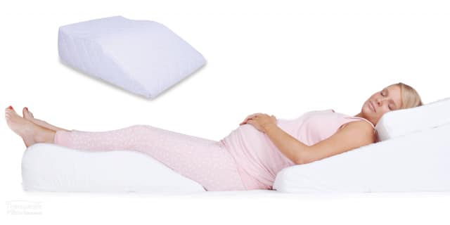 Pregnant woman using the Leg Relaxer Pillow available online or in-store at The Back and Neck Bed Shop