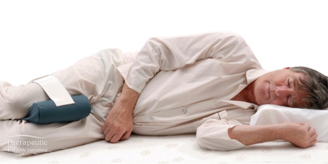 Older man using the Leg Spacer Cushion available online and in-store at The Back and Neck Bed Shop