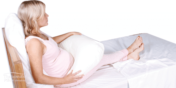 pregnant woman with a side snuggler baby feeding body pillow