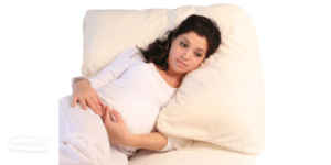 Pregnant woman lying on a Lucky 7 Comfort Pillow