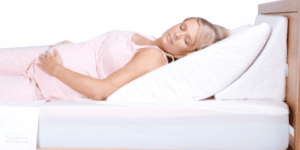 Pregnant woman sleeping on a wedge pillow for body support