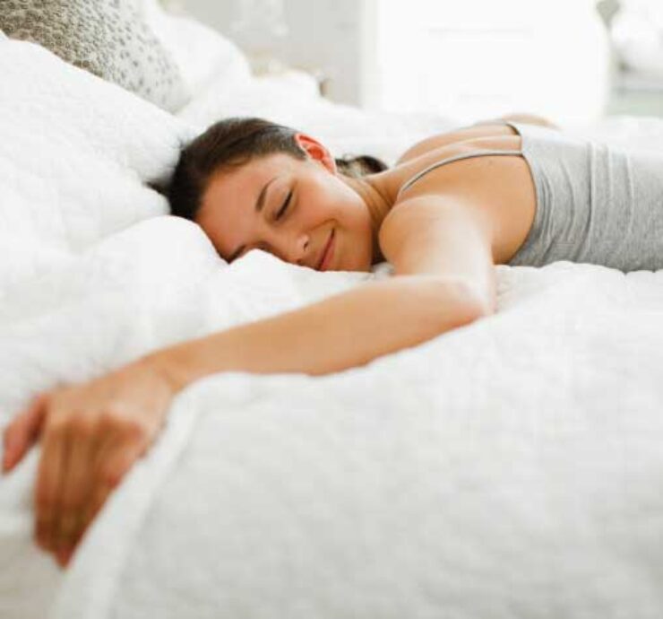 smiling woman sleeping on a soft bed